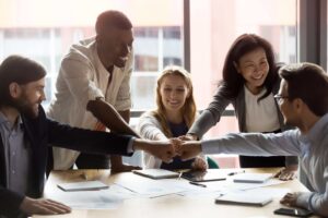 pessoas em uma reunião de trabalho juntando as mãos como um ato de trabalho em equipe