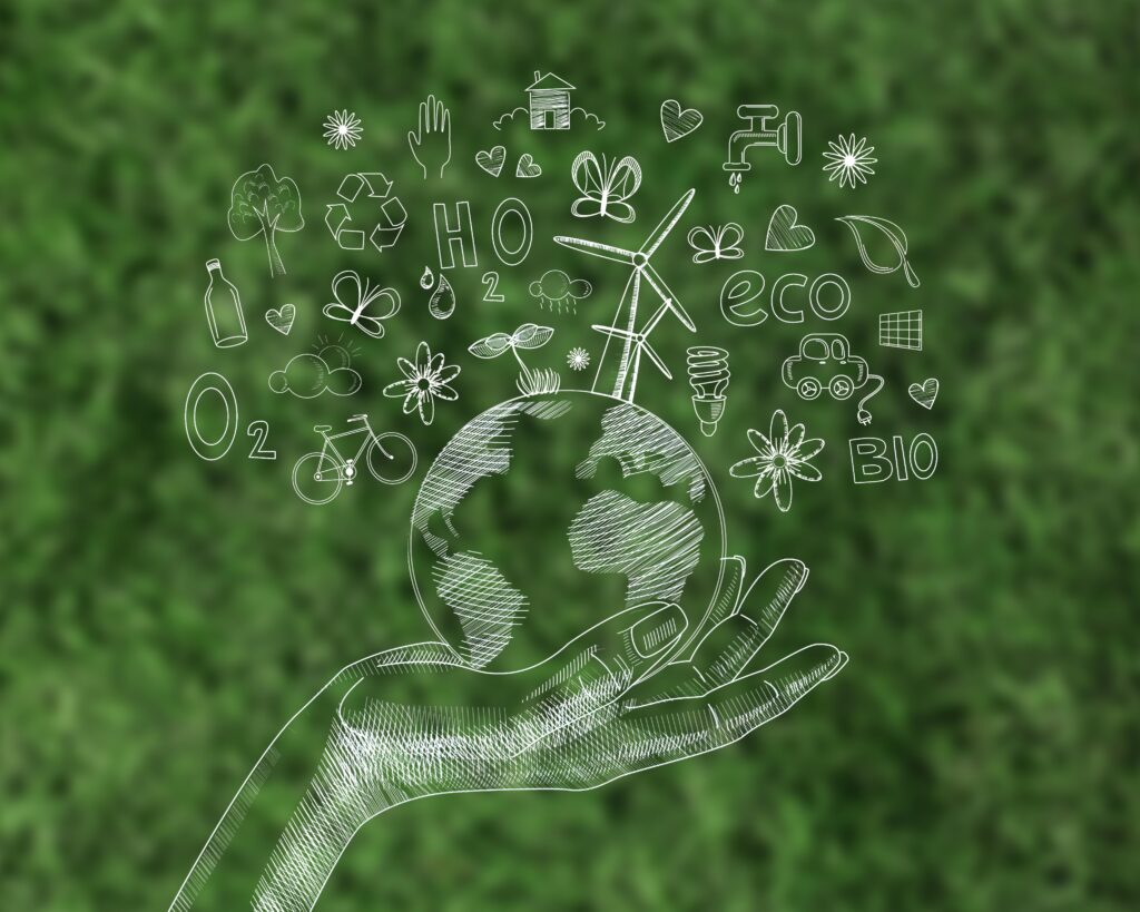 Imagem de tela digital sobre grama, com uma mão segurando o planeta e itens de sustentabilidade econômica